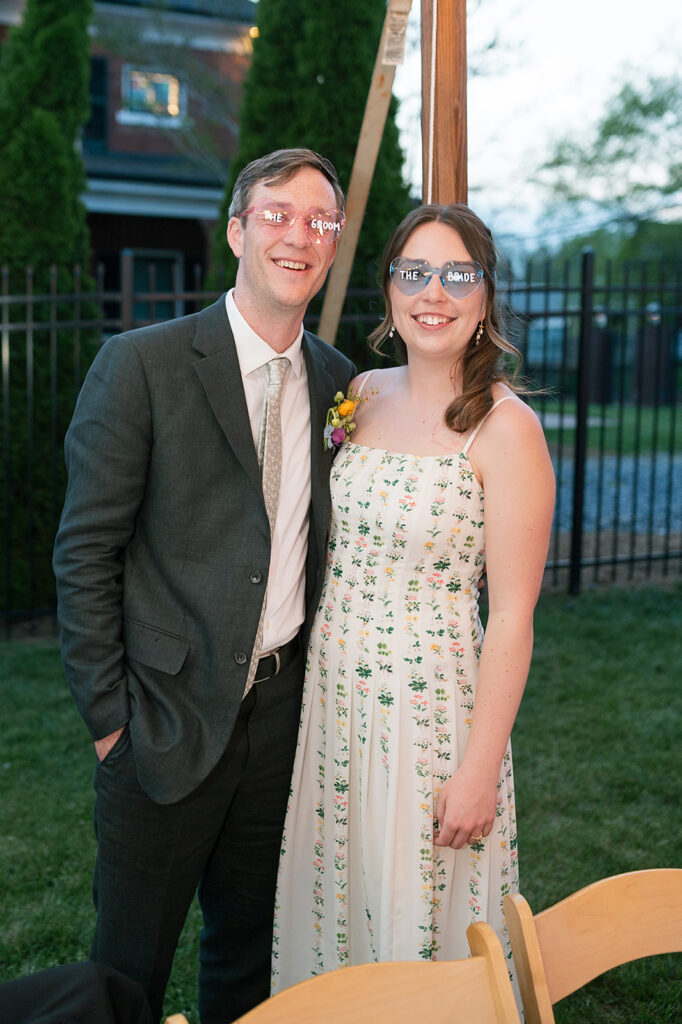Bride and groom wearing heart-shaped sunglasses