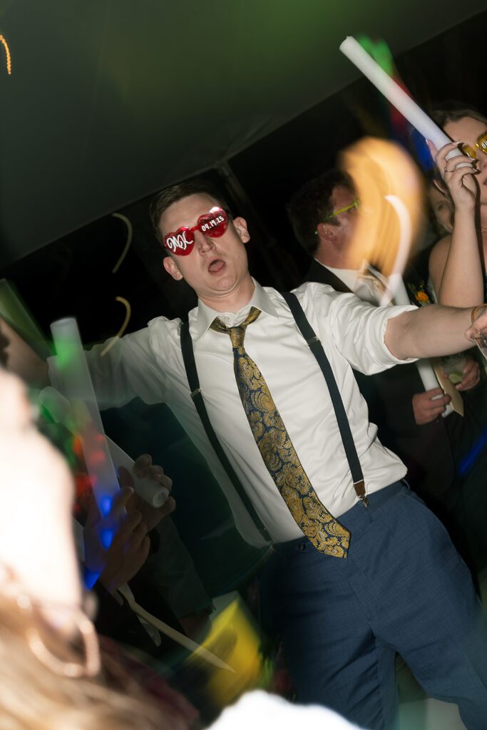 Wedding guest dancing with heart-shaped sunglasses