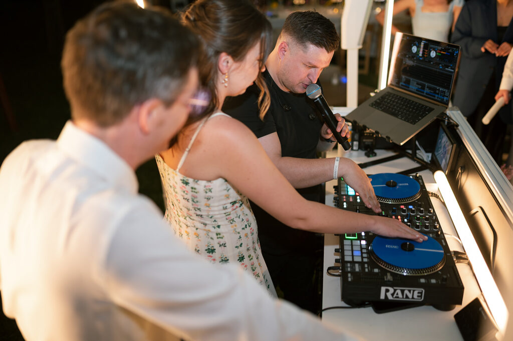 Bride and groom playing music from the DJ booth