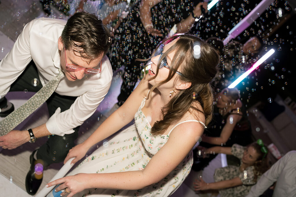 Bride and groom dancing during their wedding reception with bubbles in the air