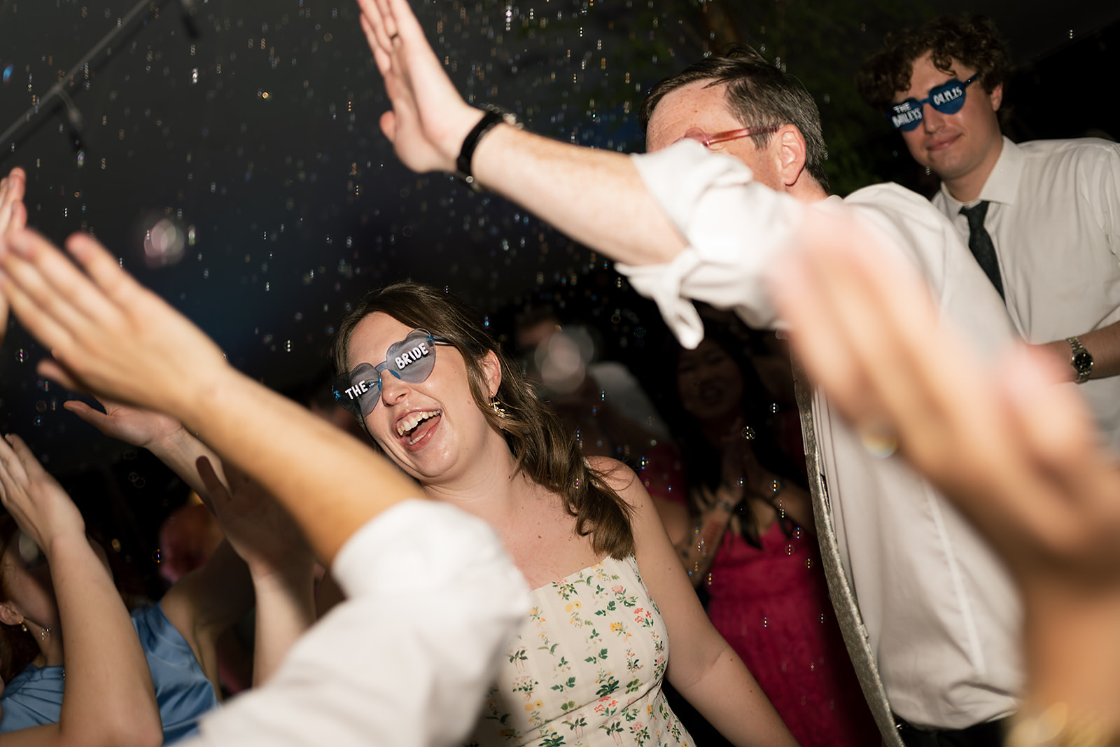 Bride and groom dancing during their wedding reception with bubbles in the air