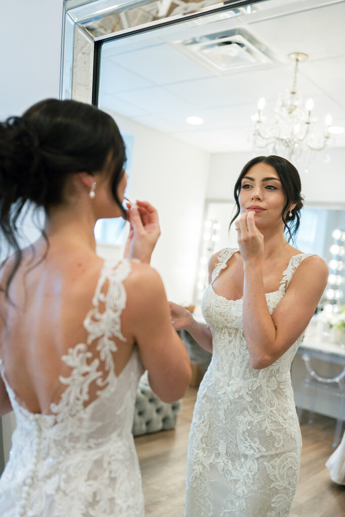 Bride applying makeup in the mirror