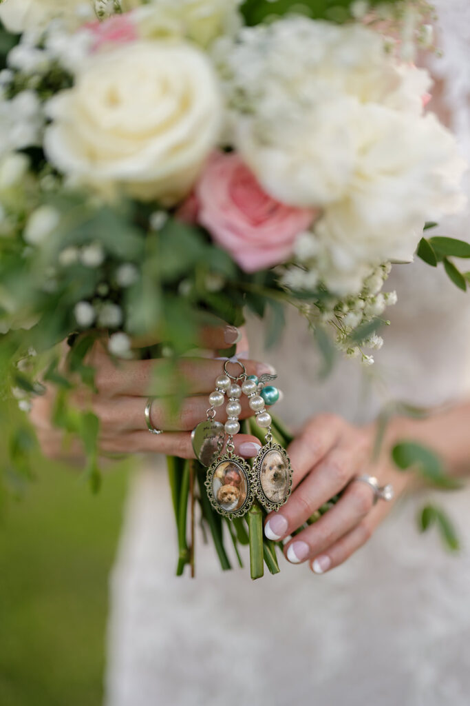 Close up shot of a bride holding her wedding bouquet with memorial pieces of her dog