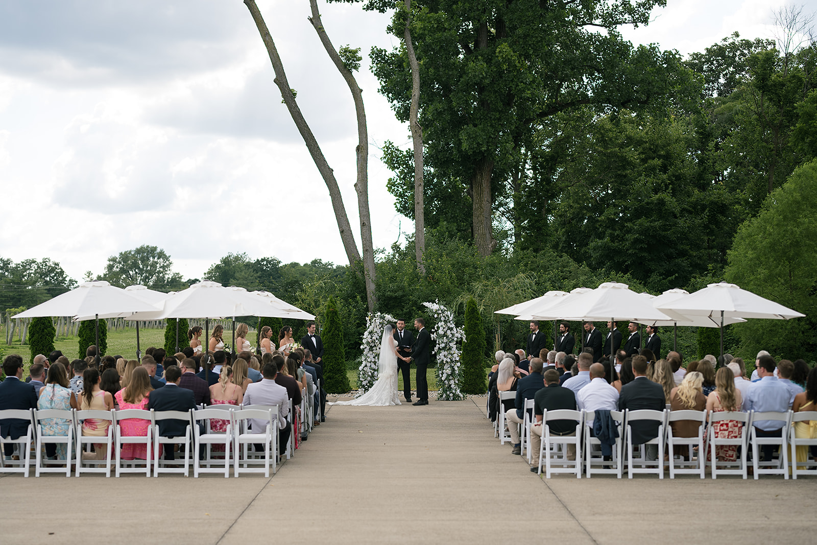 Outdoor wedding ceremony at Daniel’s Vineyard with guests seated under umbrellas