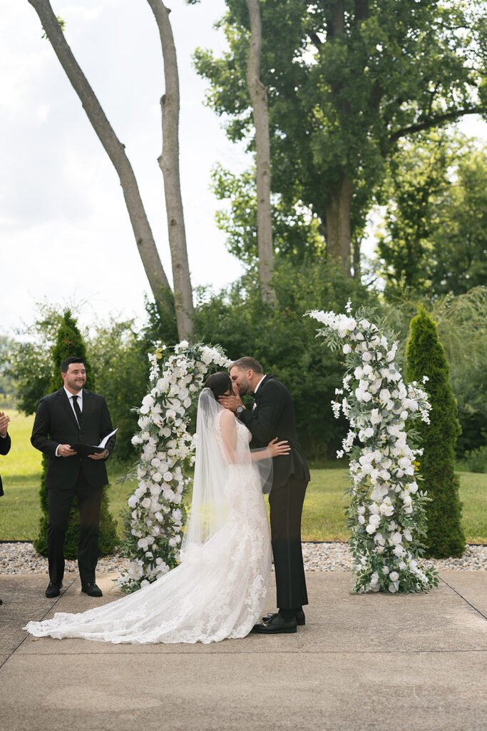 Bride and groom kissing during their outdoor wedding ceremony