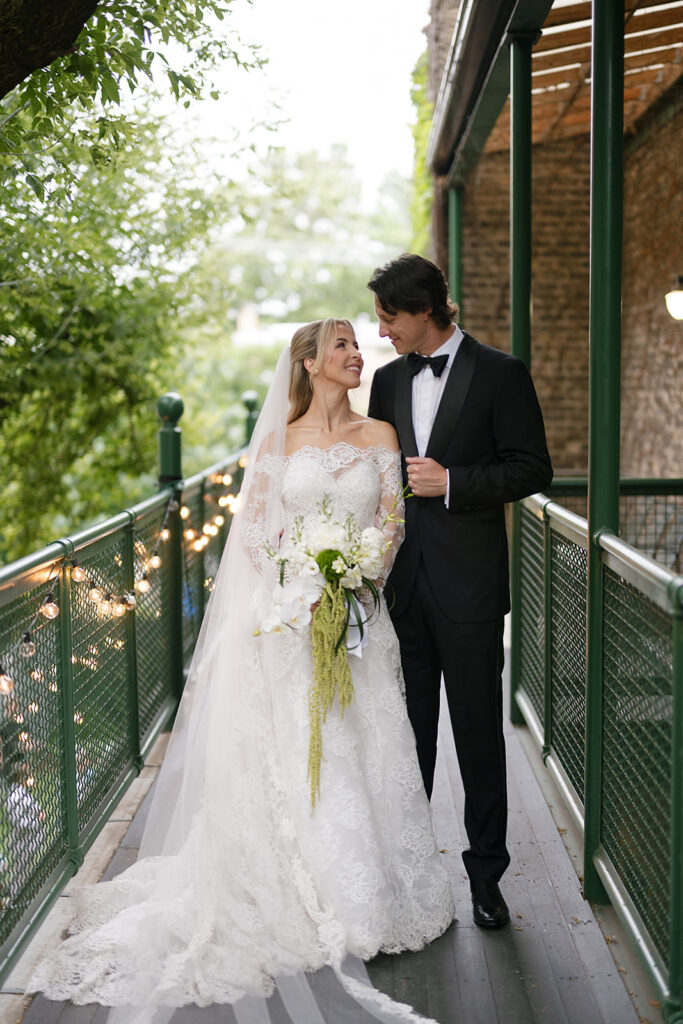 Bride and groom smiling at each other on the balcony at Chicago Firehouse for their micro wedding portraits