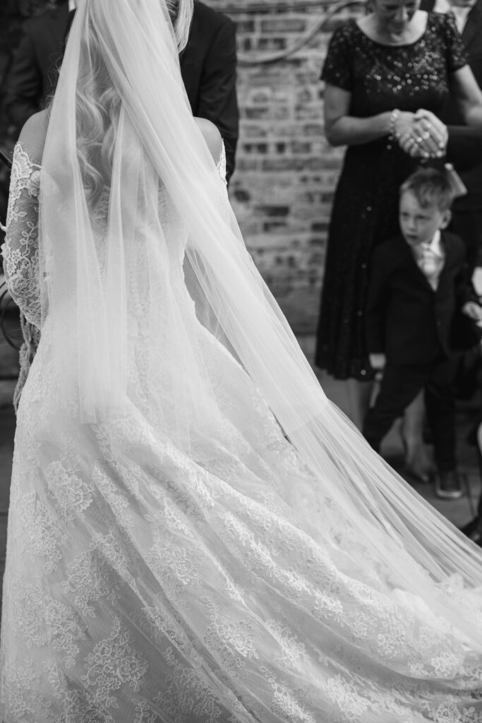 Black and white close up shot of a bride and groom standing at the altar
