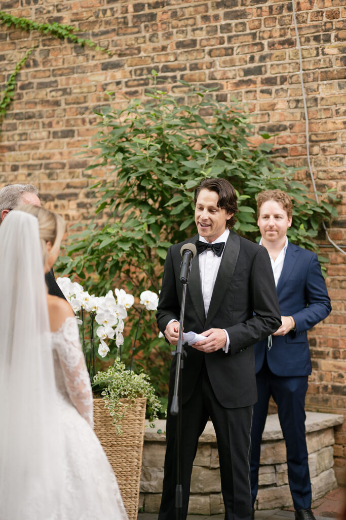 Groom reading saying his vows to his bride