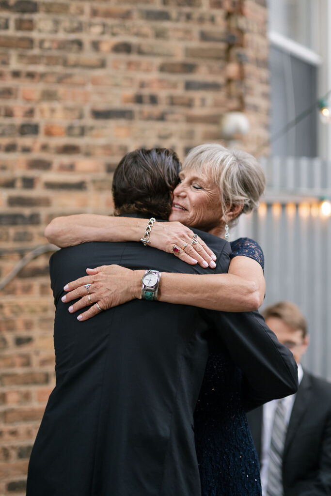 Groom hugging his mom with a big smile before the ceremony begins.
