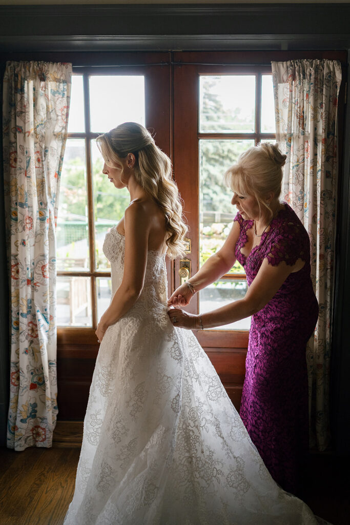 Bride getting her dress buttoned up