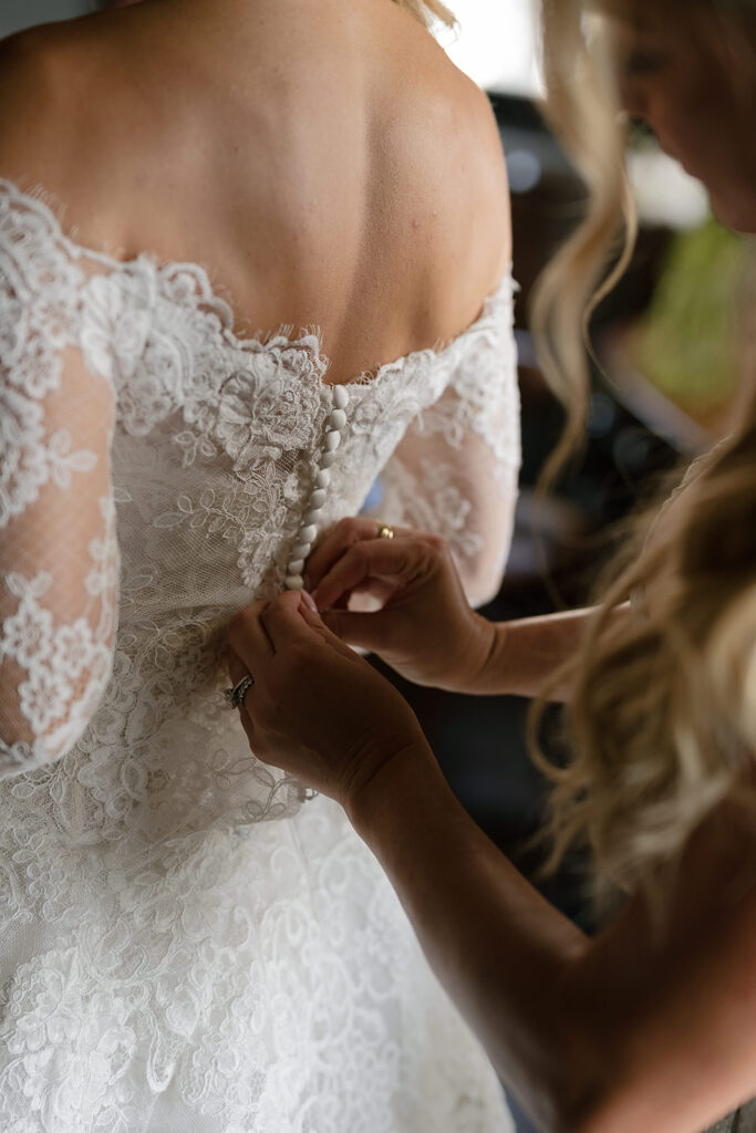 Close up shot of a bride getting her wedding dress bottoned up