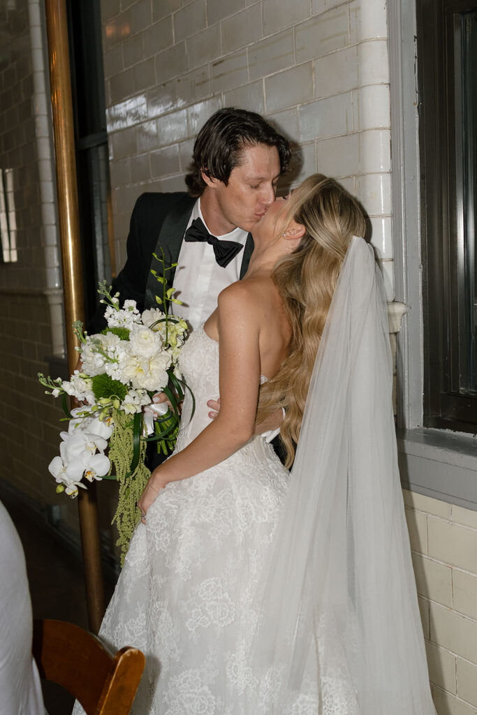 Bride and groom sharing a kiss next to the fire pole inside Firehouse Chicago.