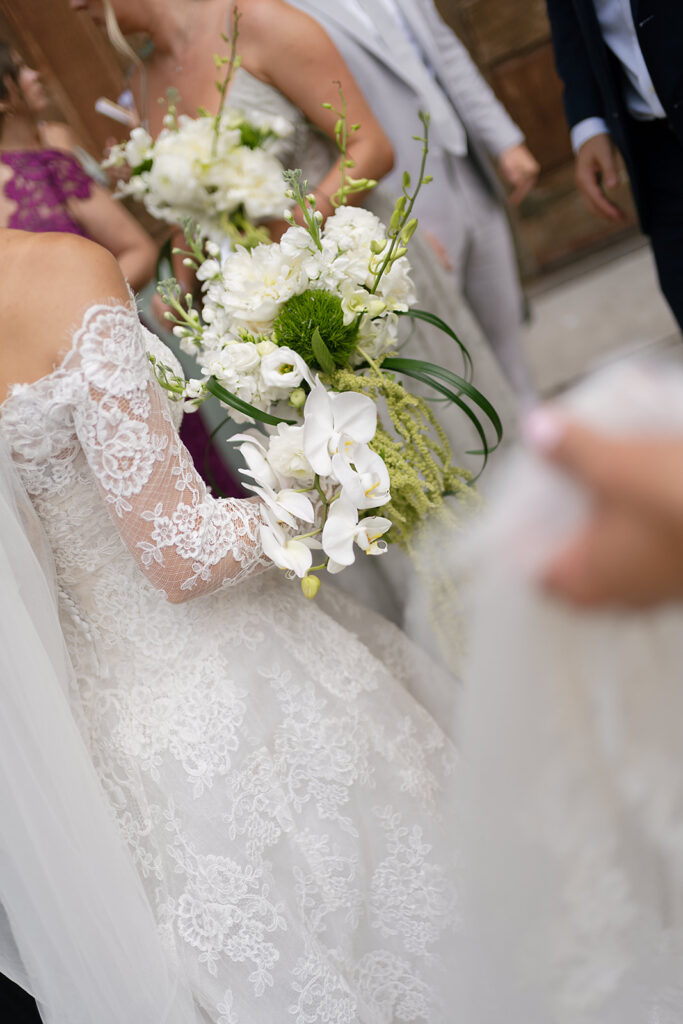 Close up shot of a bride mingling with guests during group shots 